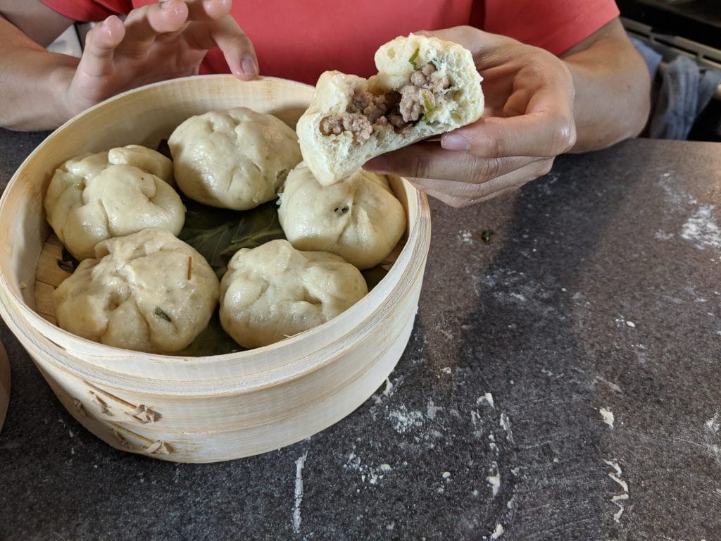 A bamboo steamer full with tasty pork bao, or pork buns.