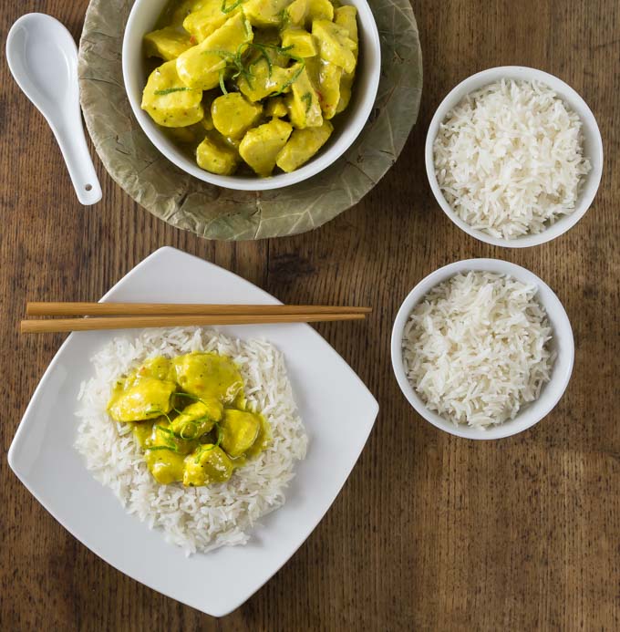 A yellow chicken amok curry on top of a bed of white rice