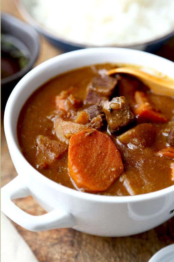 A thick brown savory curry, with beef, carrots, potato, onion, and apples