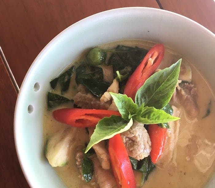 A white soupy curry with tuna fish, red chili peppers, shallots, and coconut cream