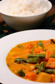 An orange curry with green beans, sweet potatoes, pumpkin, and carrots