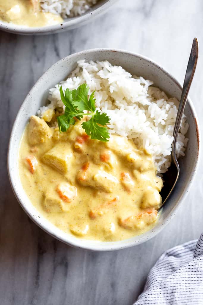 A yellow Thai curry with chunks of chicken and a big scoop of rice