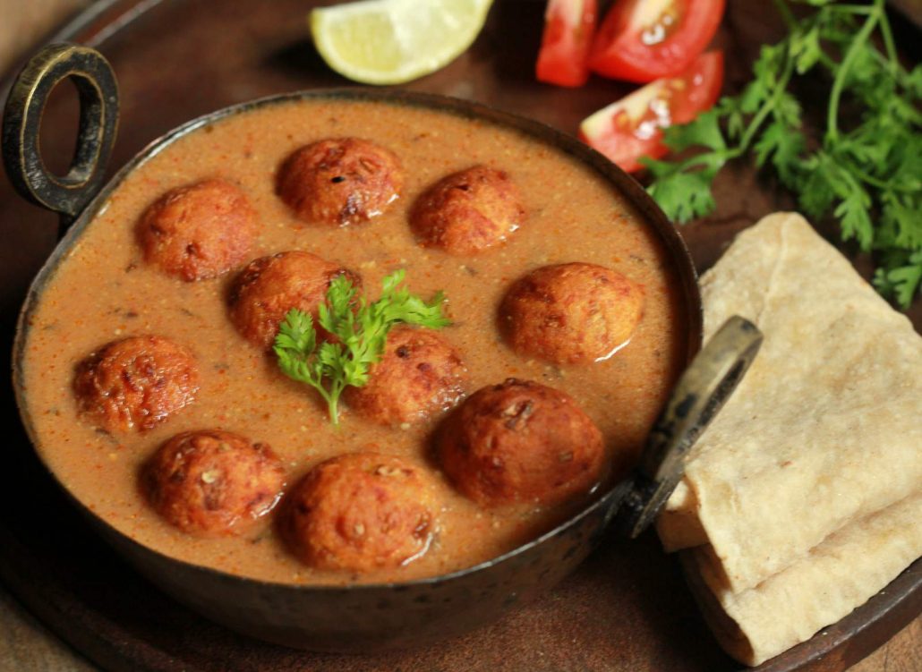 A light brown kofta curry, with ball shaped fried dumplings