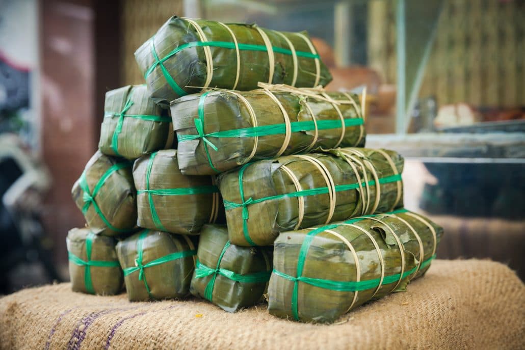 Sticky rice rolls wrapped in a banana leaf, called bahn tet