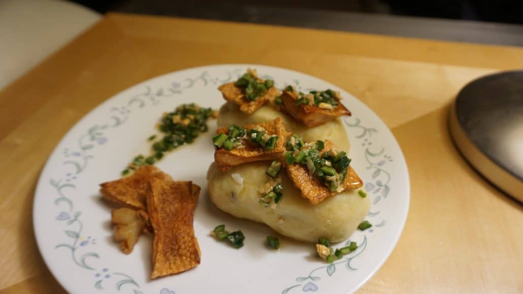 Finished chapalele with pork cracklings and minced serrano pepper on top