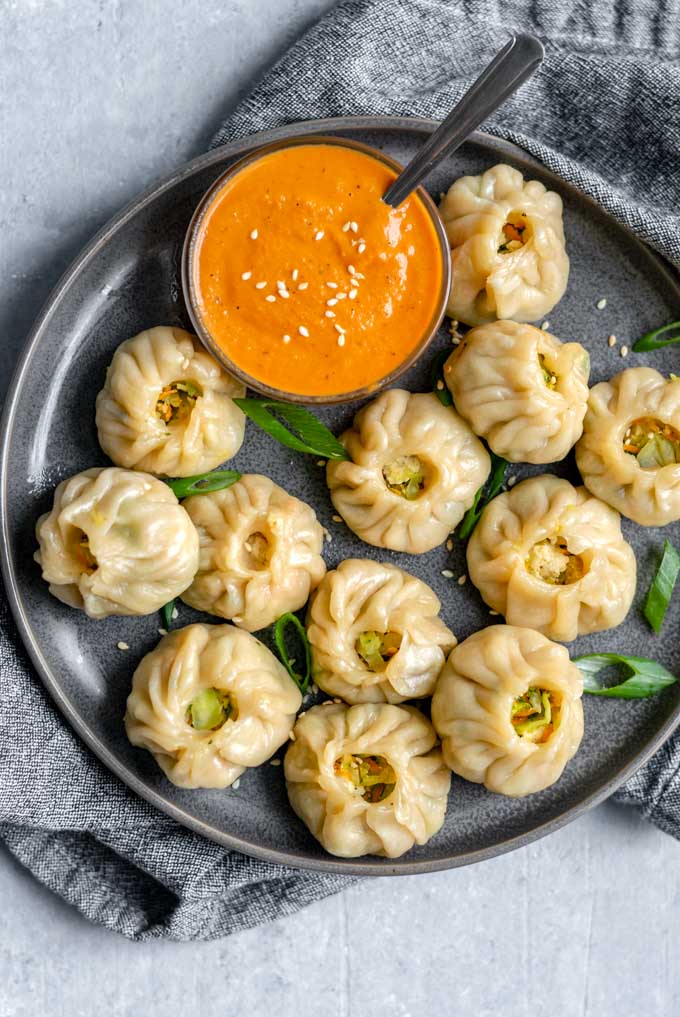 Tibetan dumplings called momos with an orange dipping sauce