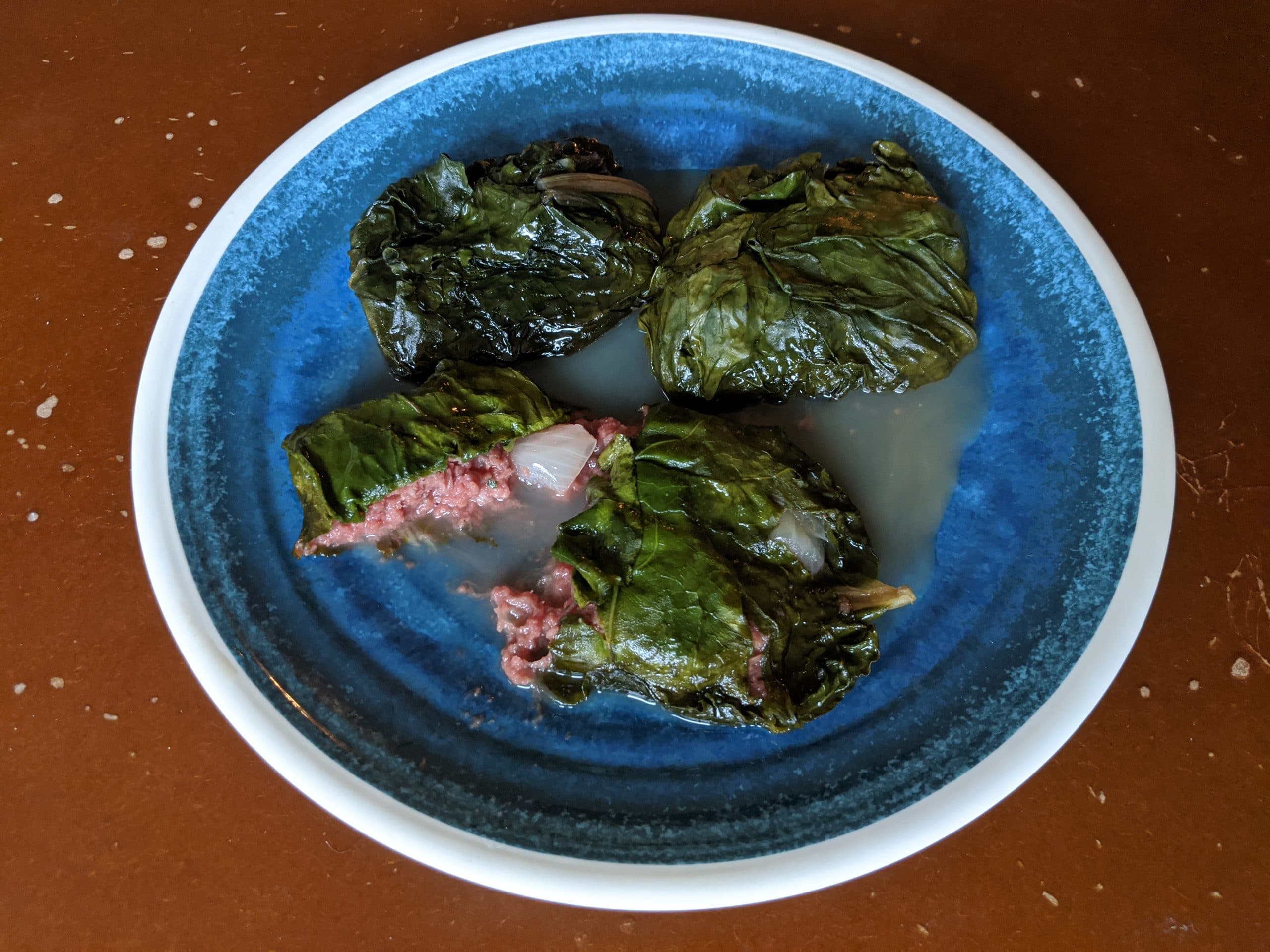 3 Palusami on a plate, with coconut cream on the bottom