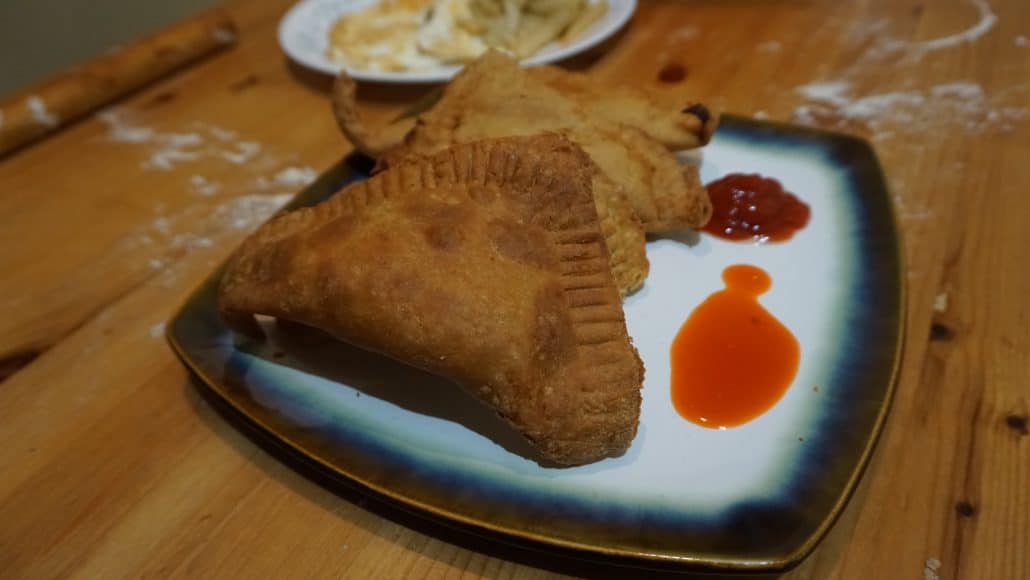 4 fataya on a plate with hot sauce and ketchup