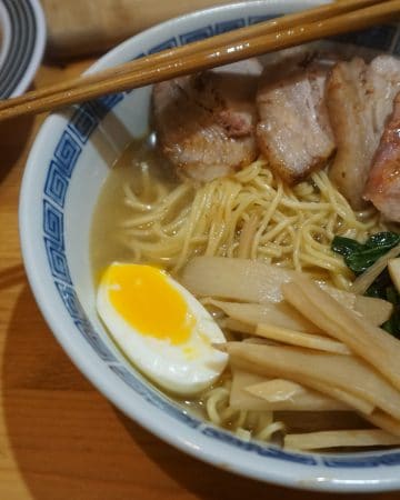 A bowl of shio ramen with bamboo shoot, spinach, pork, and egg