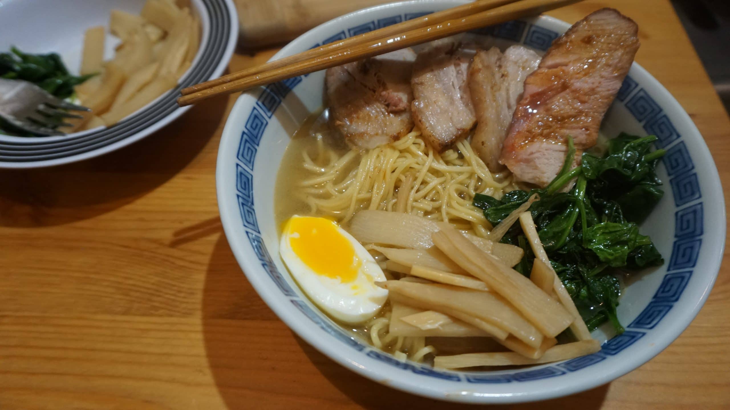 A bowl of shio ramen with bamboo shoot, spinach, pork, and egg