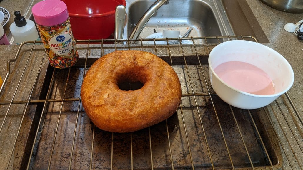 Cooked donut on a wire rack, about to be glazed