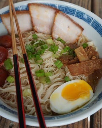 A bowl of Asahikawa ramen, with char siu pork belly, menma, green onion, softboiled egg, and pickled plums
