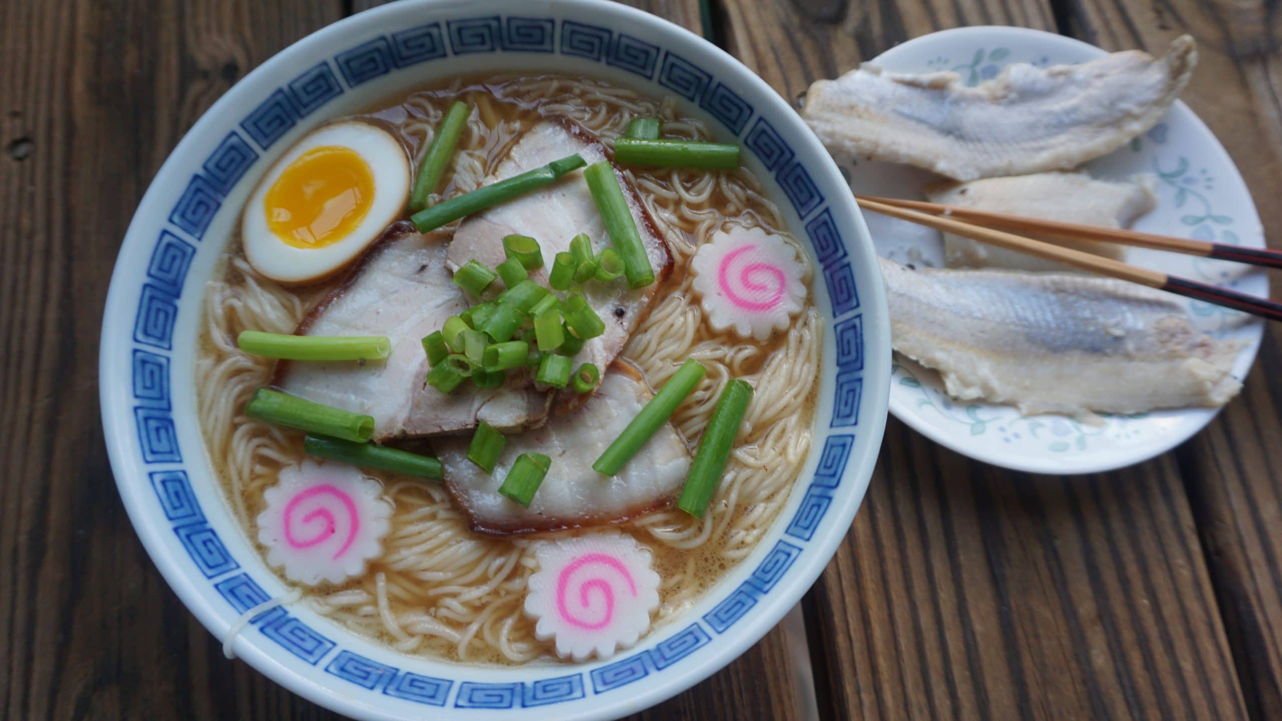 A bowl of Wakayama ramen with a plate of pickled mackerel on the side