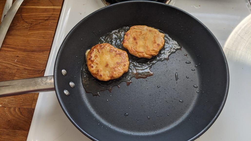 Frying arepas in a skillet for the bandeja paisa