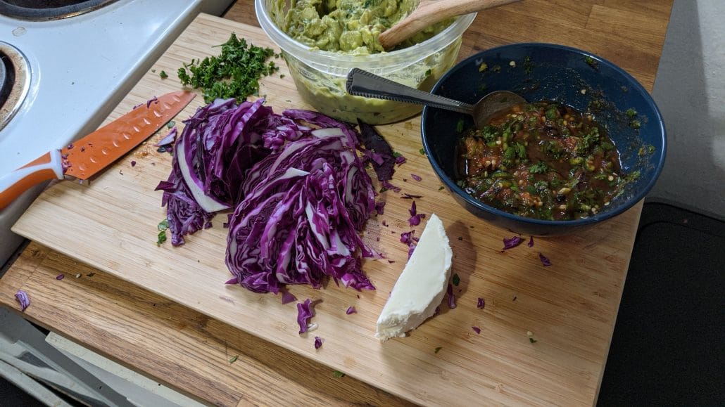 Toppings for the mixtas, including guacamole, queso fresco, chirmol, and red cabbage